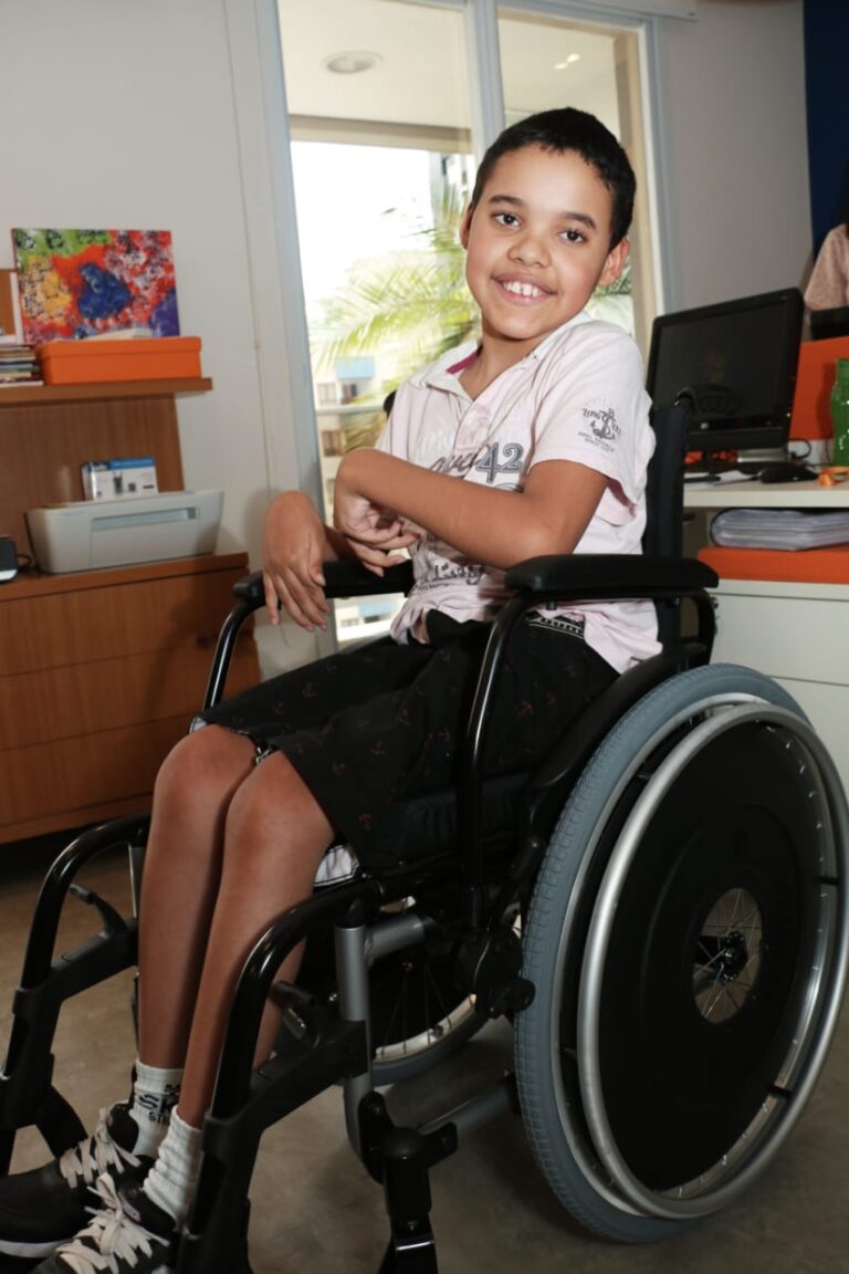 Criança participantes da Turma do Jiló em uma cadeira de rodas